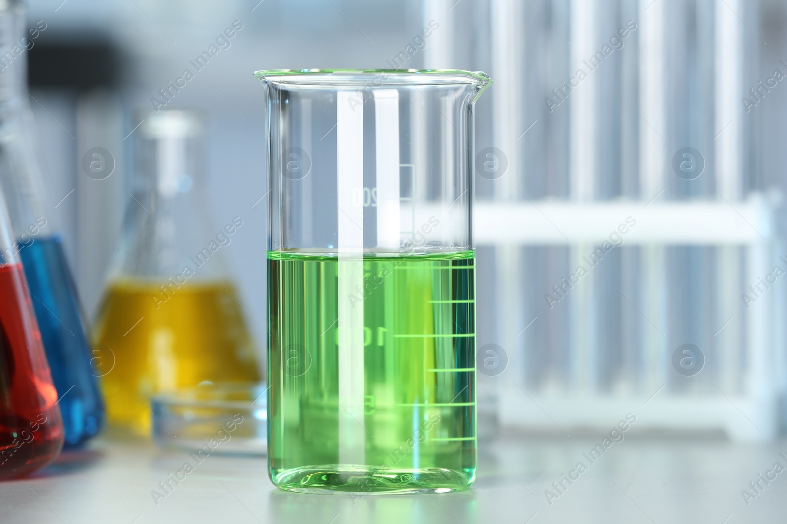 Photo of Beaker with colorful liquid on table in laboratory