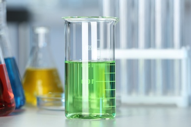 Beaker with colorful liquid on table in laboratory