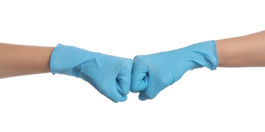 Photo of Doctors in medical gloves making fist bump on white background, closeup