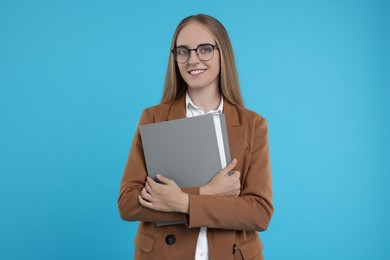 Photo of Happy young secretary with folder on light blue background