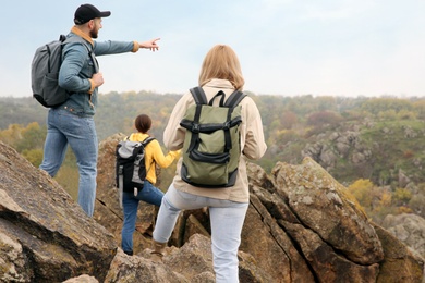 Photo of Group of hikers with backpacks at top of mountain