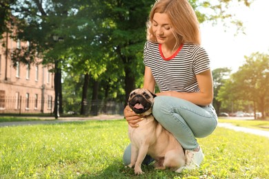 Photo of Woman with cute pug dog outdoors on sunny day, space for text. Animal adoption