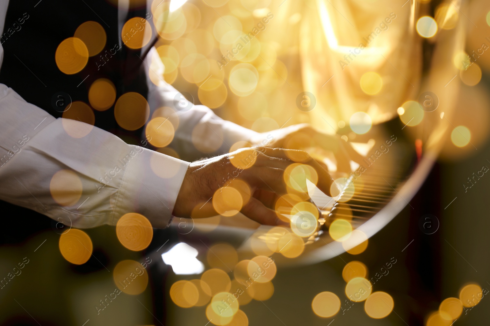 Image of Christmas and New Year music. Man playing piano, closeup. Bokeh effect