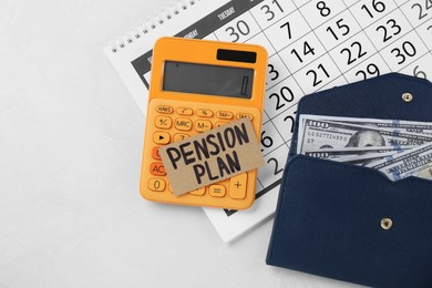 Photo of Card with phrase Pension Plan, dollar banknotes, calculator and calendar on white table, flat lay