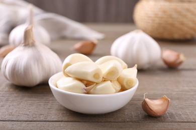 Photo of Aromatic garlic cloves and bulbs on wooden table, closeup