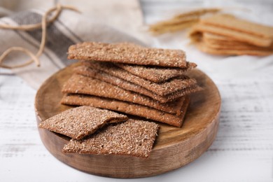 Photo of Stack of dry rye crispbreads on white wooden table