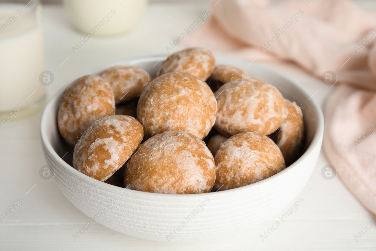 Photo of Tasty homemade gingerbread cookies in bowl on white table, closeup