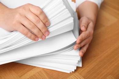 Man stacking documents at wooden table, top view