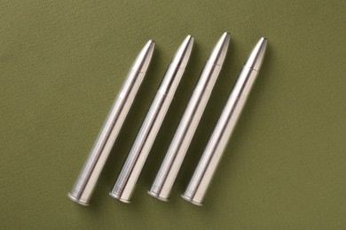 Photo of Many metal bullets on green background, flat lay