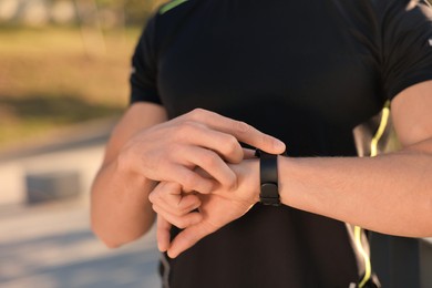 Photo of Man checking pulse after training outdoors, closeup. Space for text