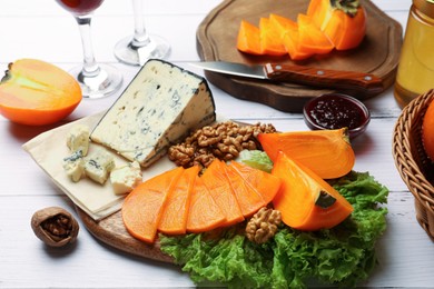 Delicious persimmon, blue cheese and nuts served on white wooden table