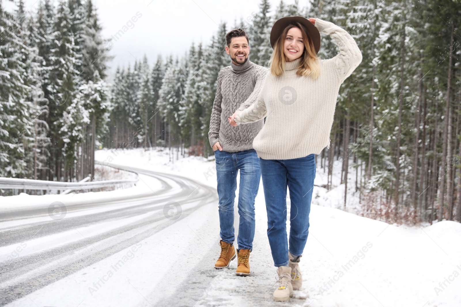 Photo of Couple walking near snowy forest, space for text. Winter vacation