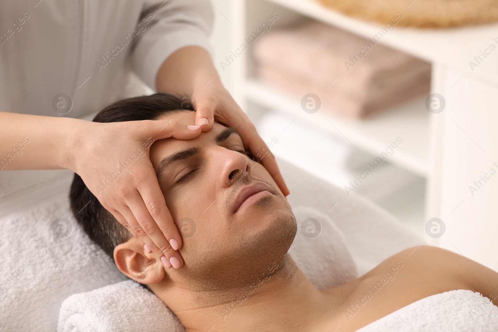 Photo of Man receiving facial massage in beauty salon