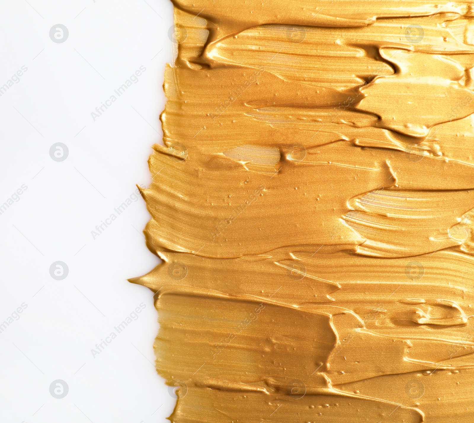 Photo of Strokes of gold paint isolated on white, top view