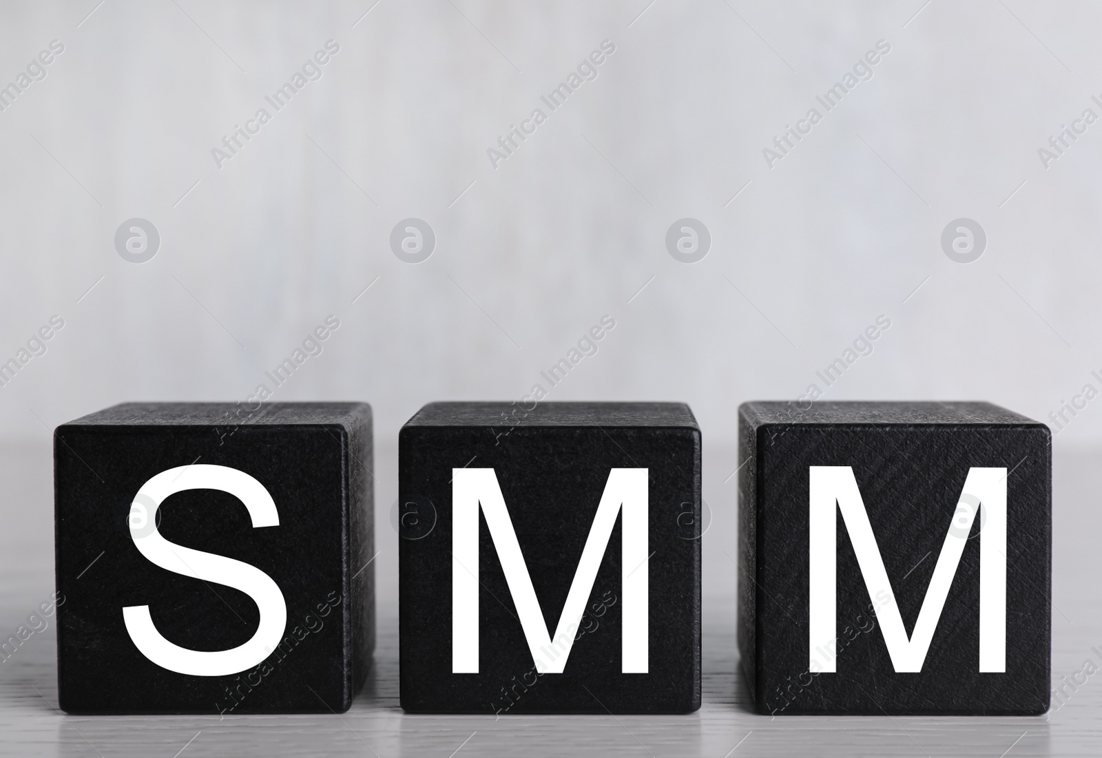 Photo of Cubes with abbreviation SMM (Social media marketing) on light grey background