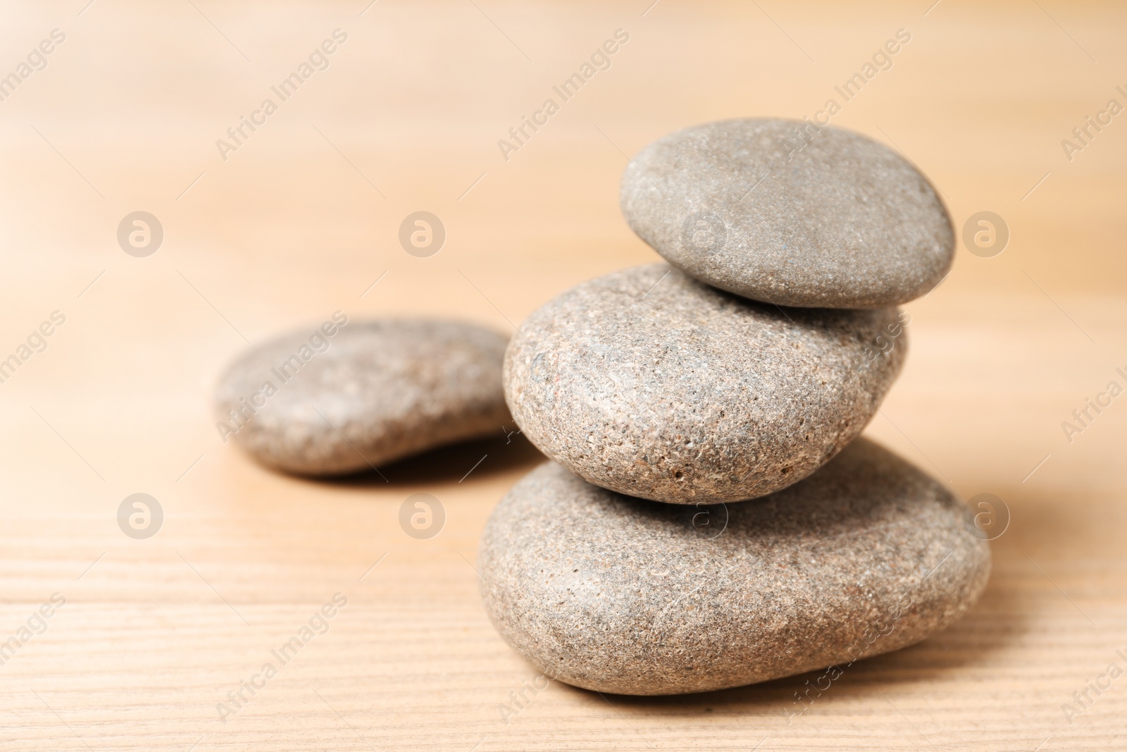 Photo of Stack of spa stones on wooden table. Space for text