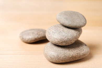 Photo of Stack of spa stones on wooden table. Space for text