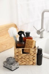 Photo of Different cleaning supplies in basket on countertop