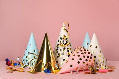 Photo of Colorful party hats and festive items on pink background