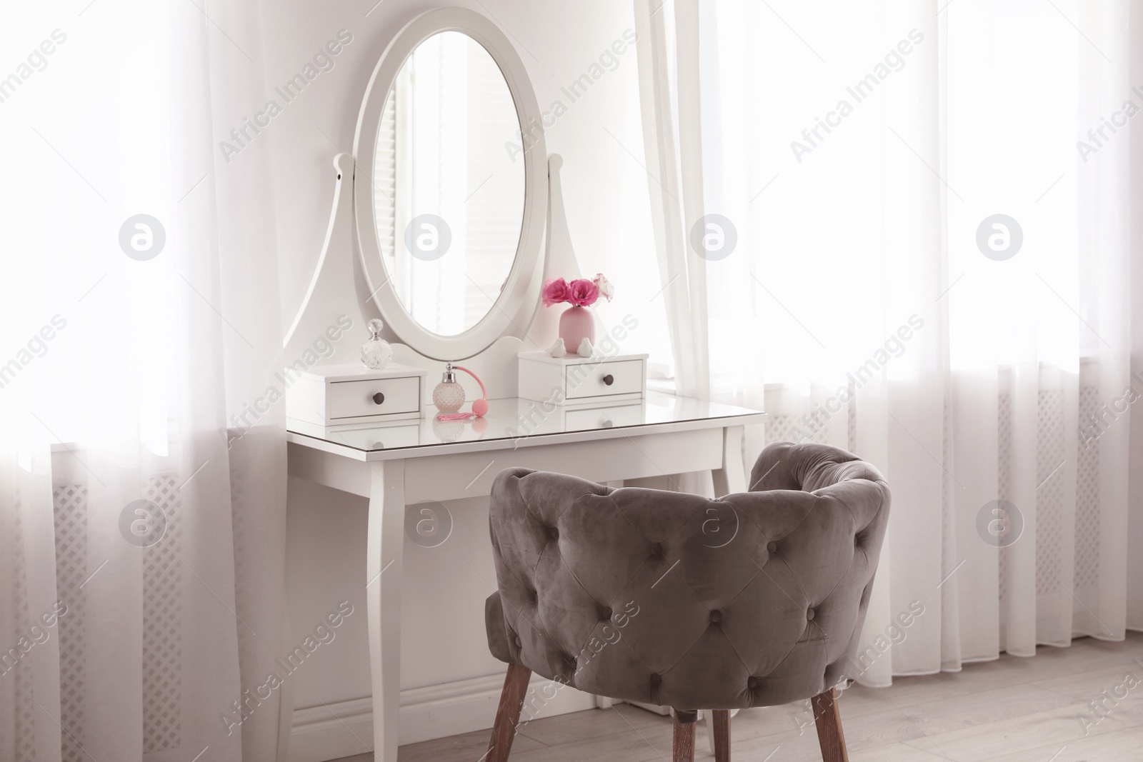 Photo of Elegant white dressing table and armchair in light room