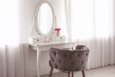 Elegant white dressing table and armchair in light room