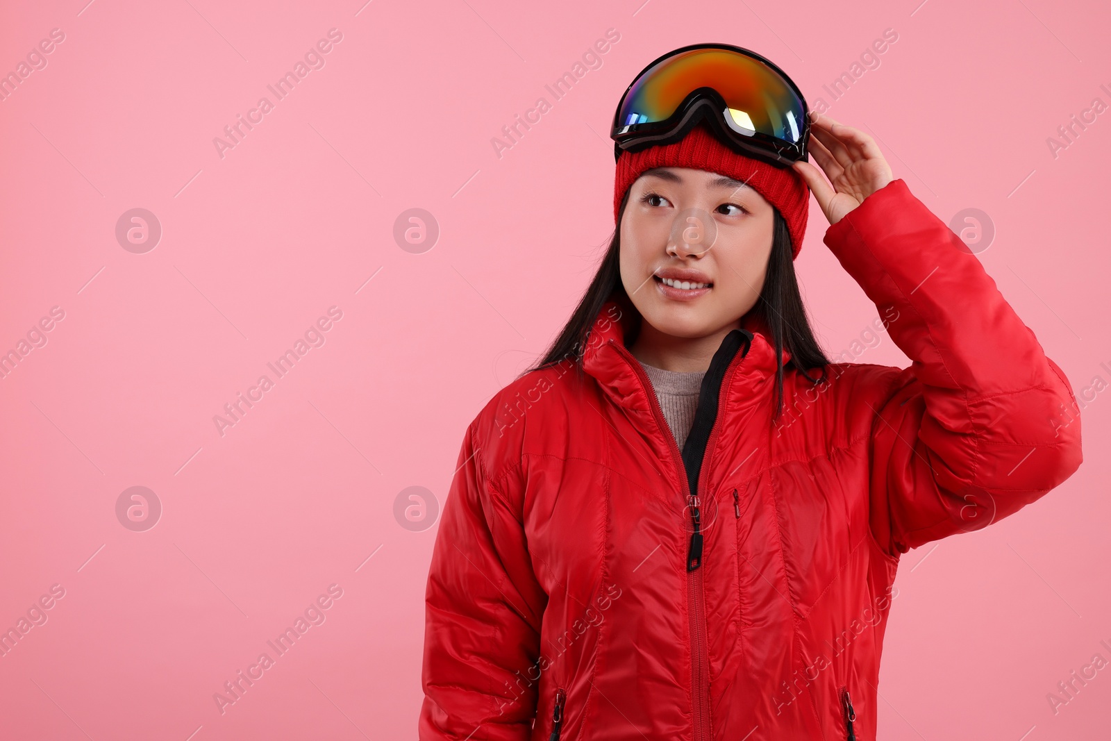 Photo of Happy woman in winter sportswear on pink background. Space for text