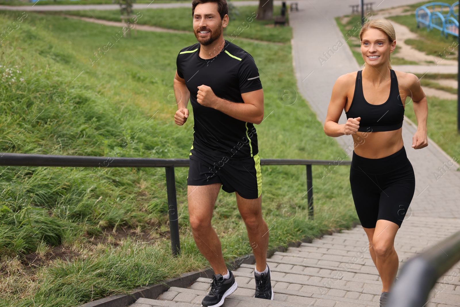 Photo of Healthy lifestyle. Happy couple running up stairs outdoors, space for text