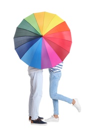 Couple hiding behind rainbow umbrella on white background