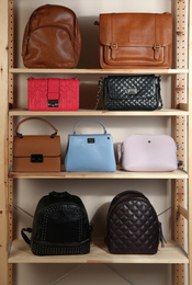 Photo of Collection of stylish leather bags on wooden shelving unit
