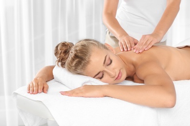 Relaxed woman receiving back massage in wellness center