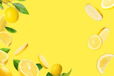 Image of Fresh ripe lemons and green leaves on yellow background. Space for text