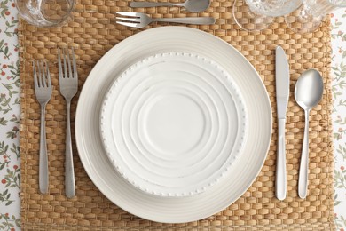 Stylish setting with cutlery, plates and glasses on table, top view