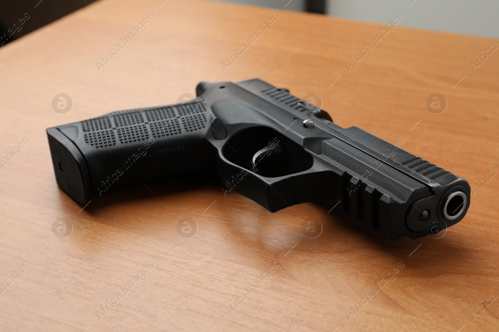 Photo of Semi-automatic pistol on wooden table. Standard handgun