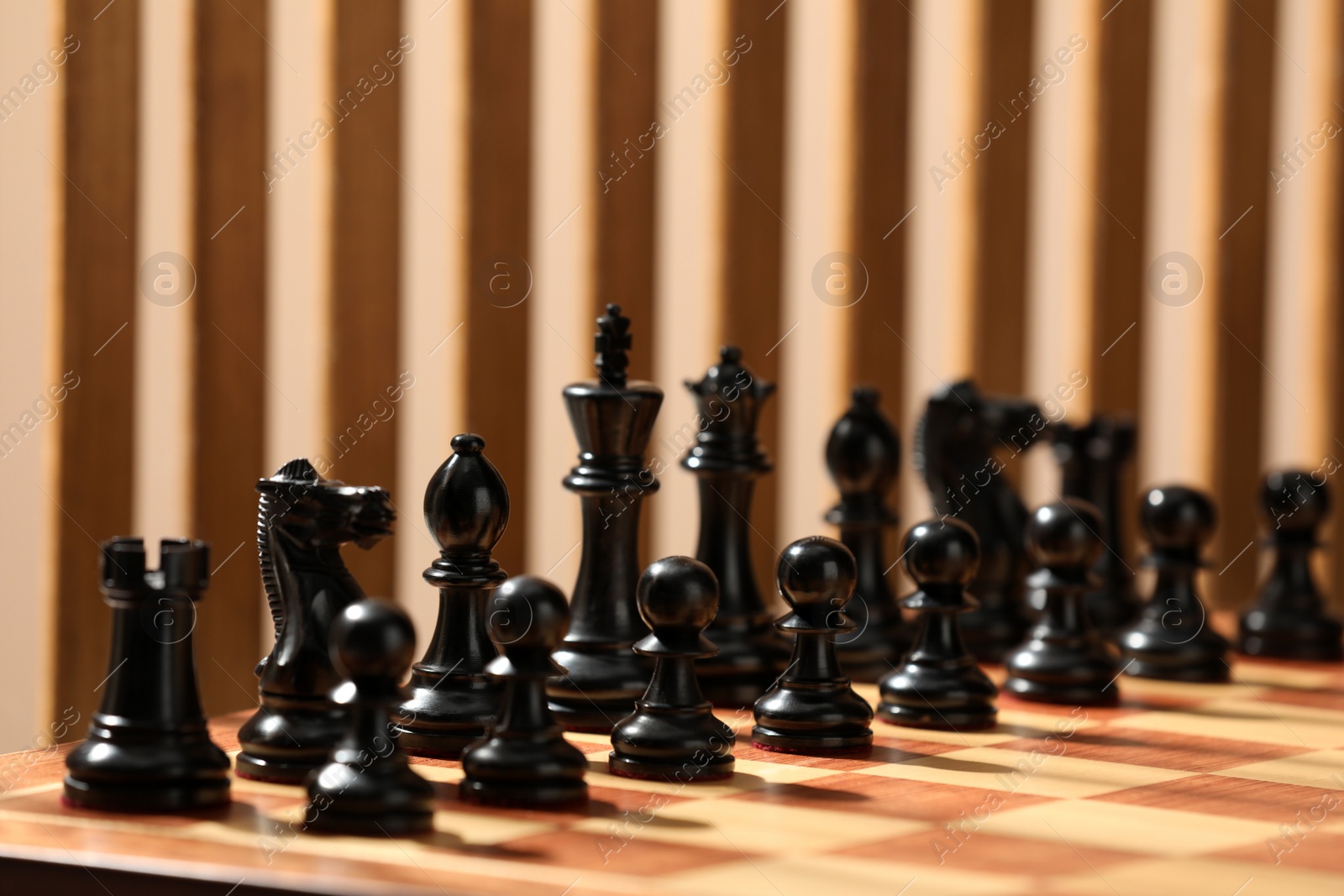 Photo of Chessboard with game pieces on color background, closeup