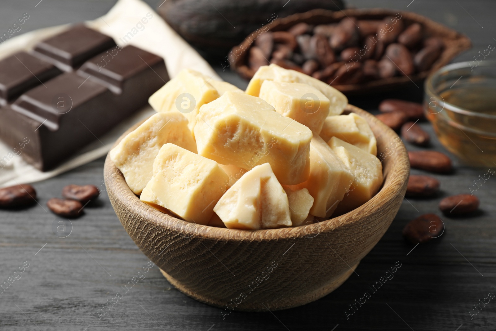 Photo of Organic cocoa butter on black wooden table, closeup