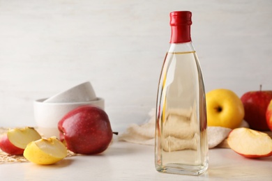 Photo of Composition with bottle of apple vinegar on table. Space for text