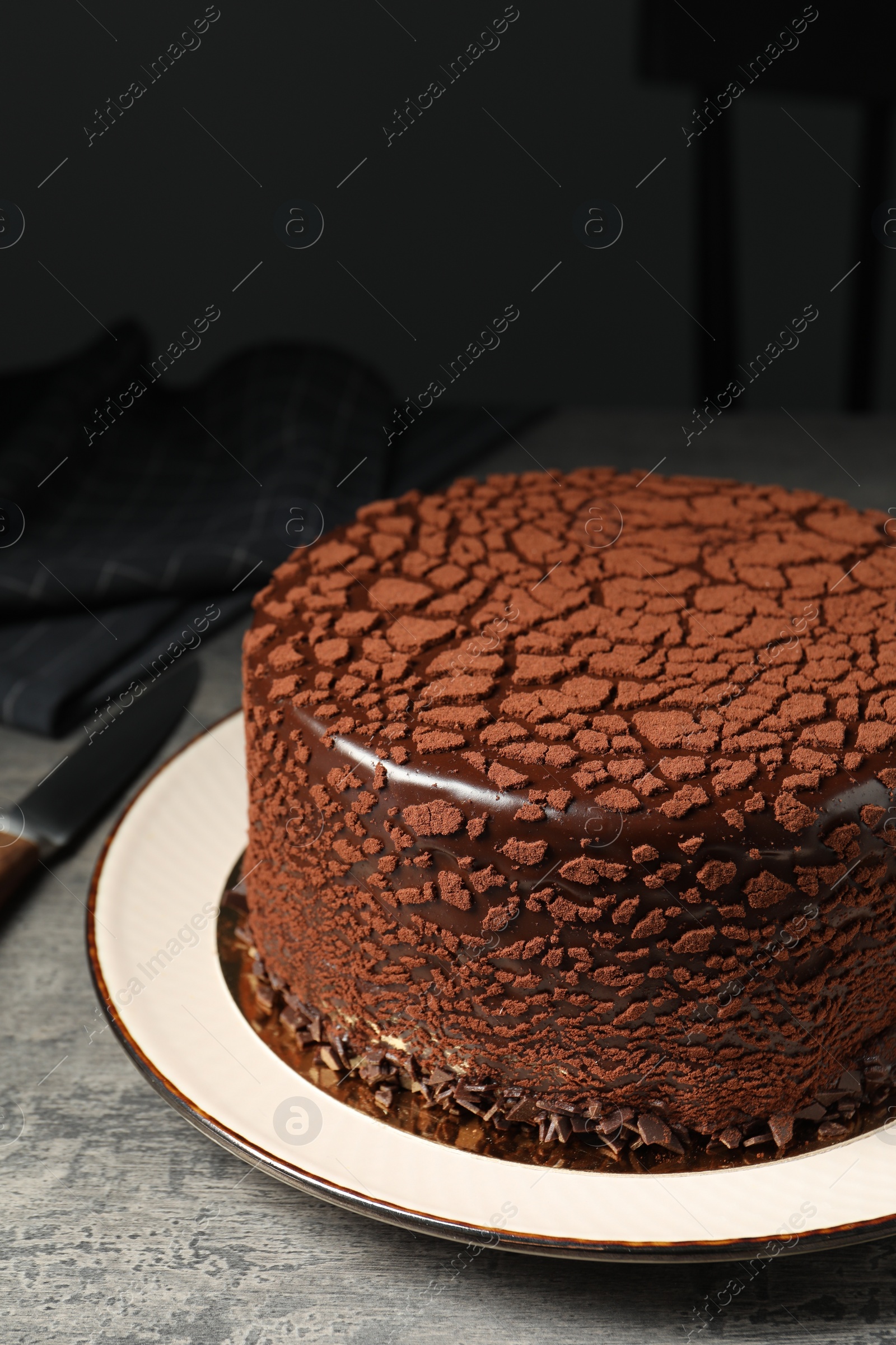 Photo of Delicious chocolate truffle cake on grey textured table