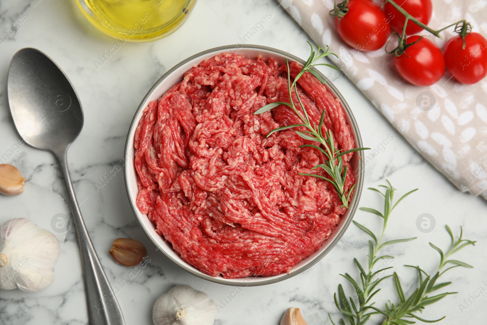 Photo of Fresh minced meat and other ingredients on white marble table, flat lay