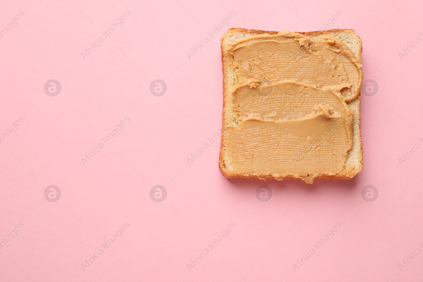 Photo of Tasty peanut butter sandwich on pink background, top view. Space for text