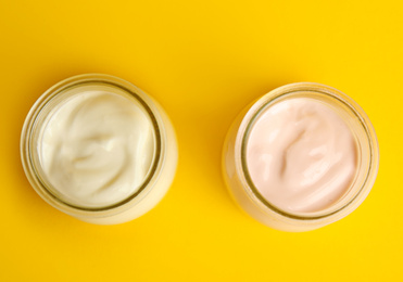 Photo of Tasty organic yogurt on yellow background, flat lay