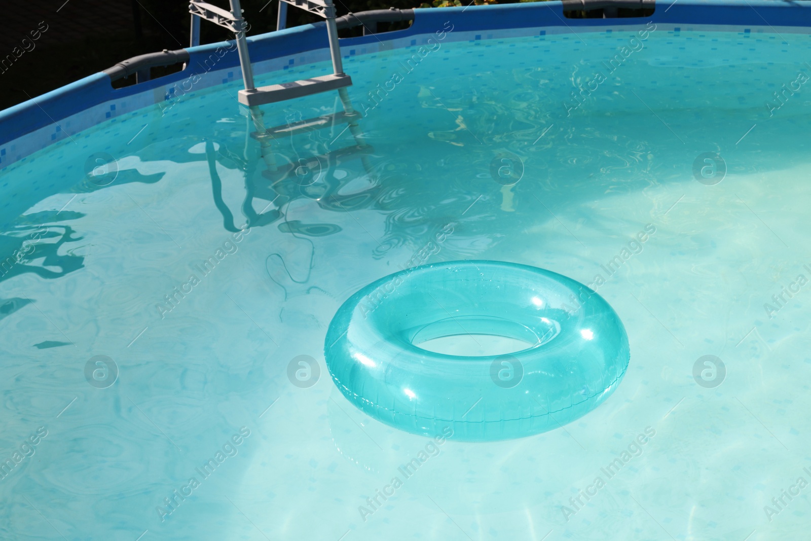 Photo of Inflatable ring floating on water in above ground swimming pool outdoors