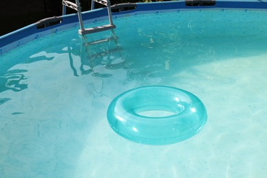 Photo of Inflatable ring floating on water in above ground swimming pool outdoors