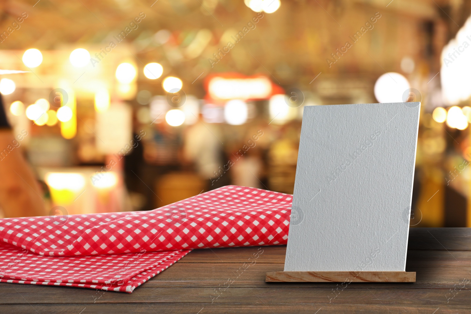 Image of Blank small board on wooden table in cafe, mockup for menu design