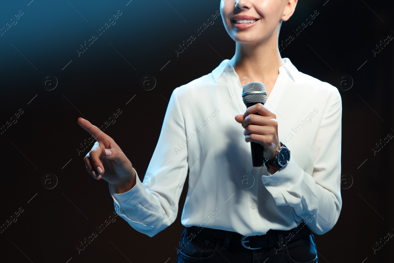 Photo of Motivational speaker with microphone performing on stage, closeup