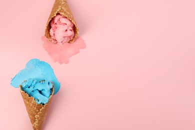 Photo of Melted ice cream in wafer cones on pink background, flat lay. Space for text