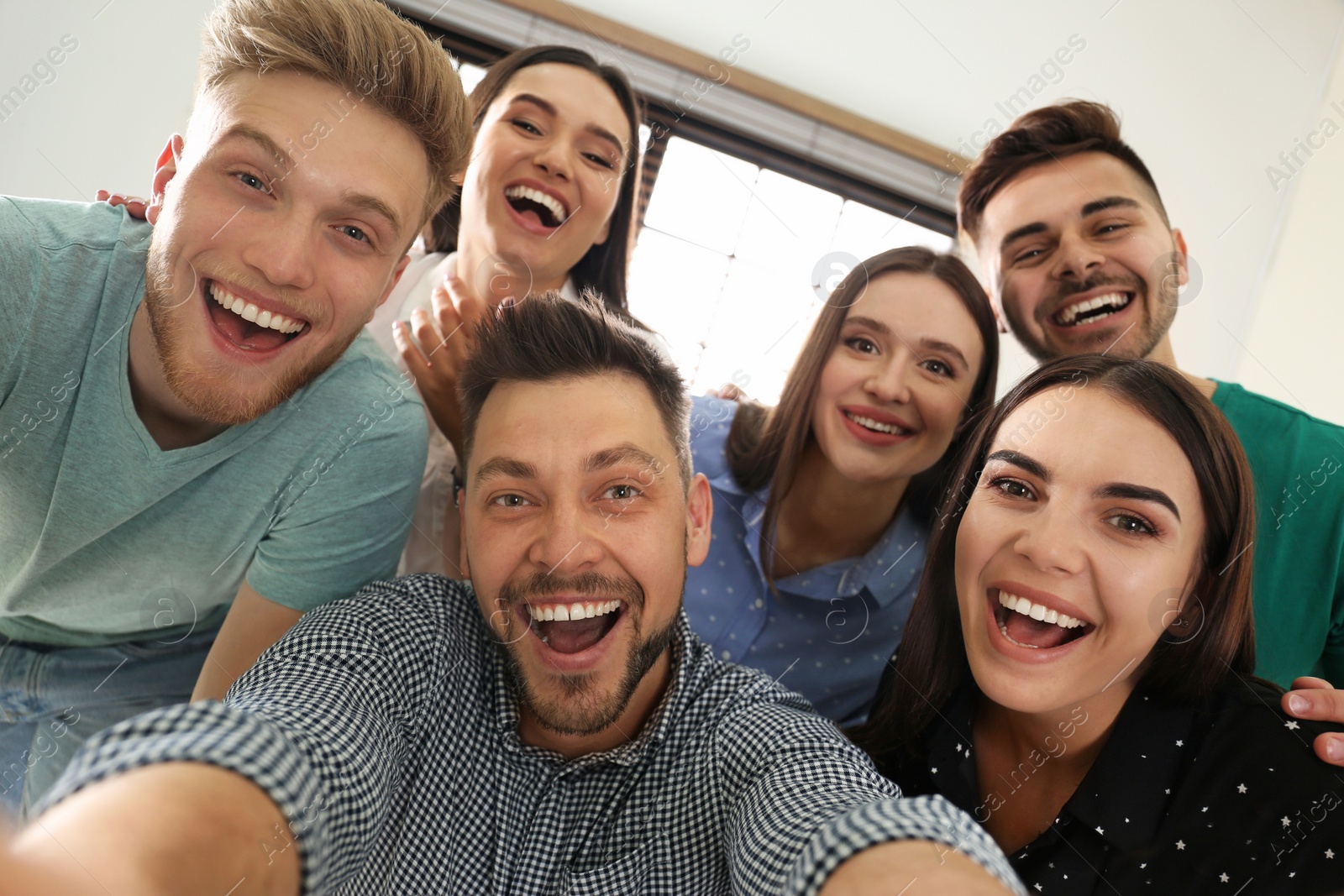 Photo of Group of happy people taking selfie in office