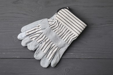 Photo of Pair of color gardening gloves on grey wooden table, top view
