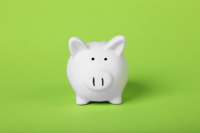 Photo of Ceramic piggy bank on light green background. Financial savings