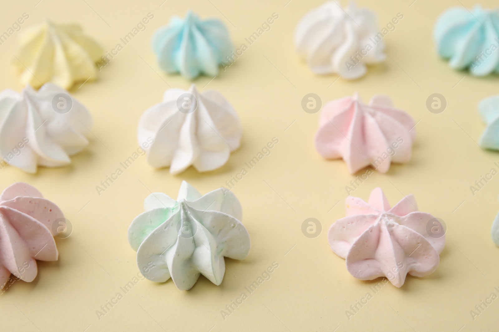 Photo of Delicious meringue cookies on beige background, closeup