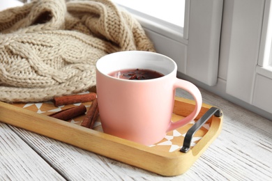 Photo of Composition with cup of hot winter drink on sill near window. Cozy season